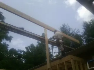 Carpenter setting a ridge beam over a new addition frame — Ice Dam Removal by Roofing Brothers in Penns Grove