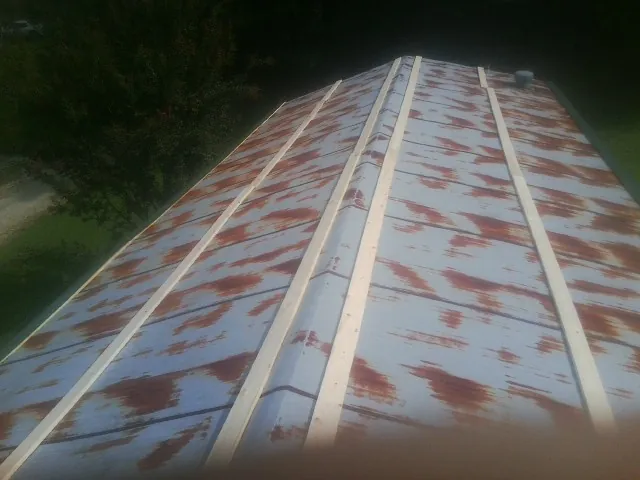 Rusted metal roof panels with new wood purlins before replacement — Storm Damage Roof Repair in Penns Grove by Roofing Brothers