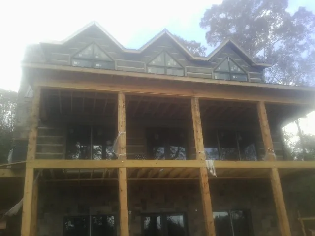 Dormers and porch framing on a large log home under construction in Penns Grove