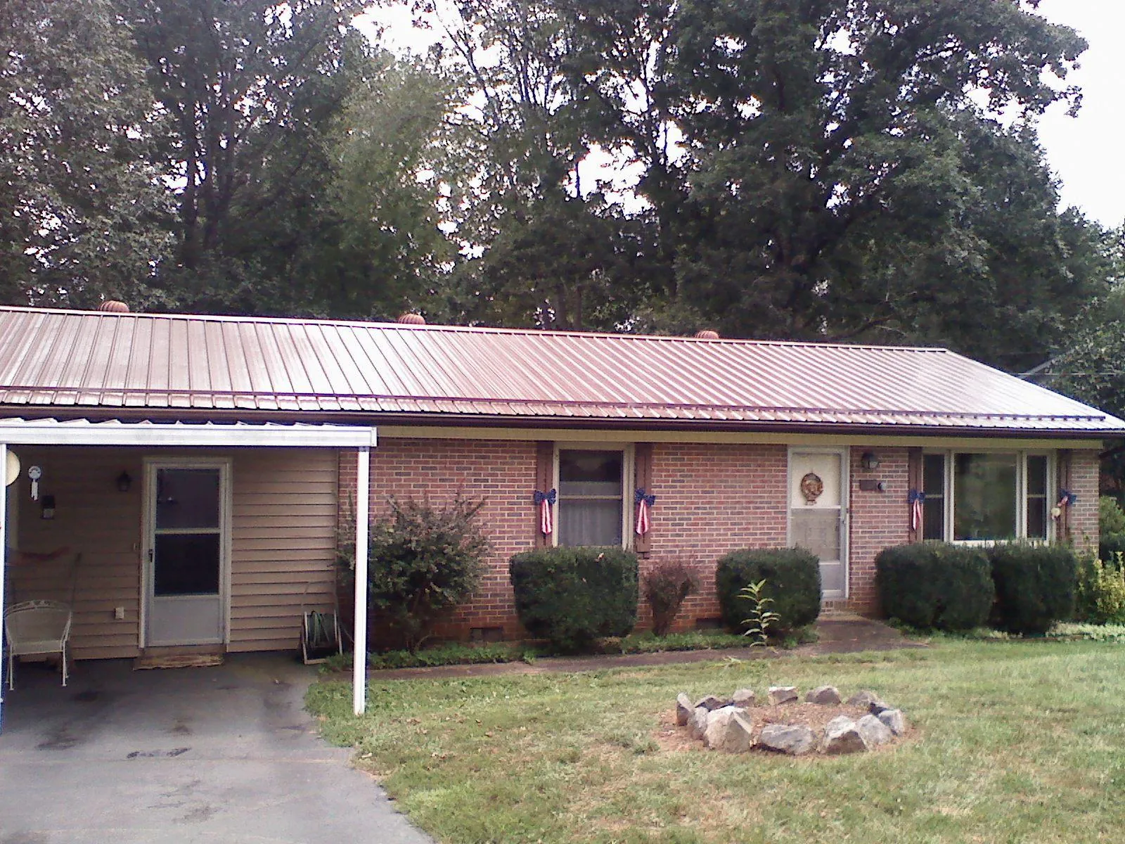 Bronze metal roof and carport on a brick ranch home — Roof Repair work by our crew in Penns Grove